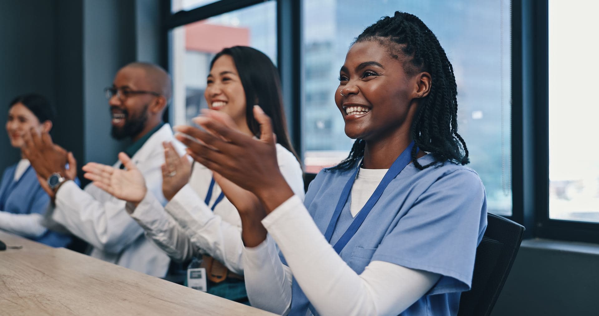 NI-BC Certification Exam Preparation Smiling medical professionals clapping at a meeting